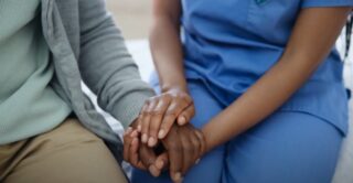 Hands of diverse medical professionals clasped together in teamwork and support